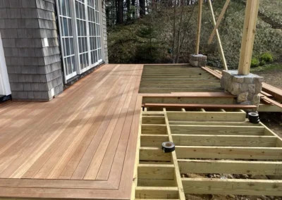 Partially constructed deck with hardwood flooring and wooden framework.