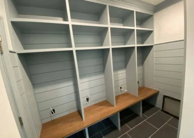 Custom-built carpentry shelving unit with integrated bench in a home entryway.