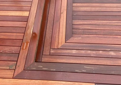 Close-up of a custom finished wooden deck with interlocking patterns and precise carpentry.