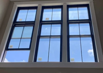 Interior view of a room with large, blue-framed windows and a chandelier.