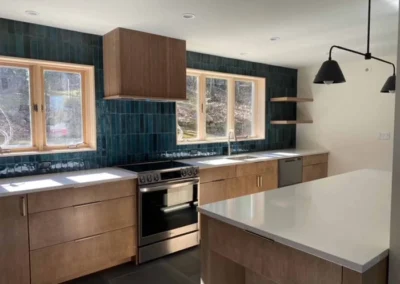Modern kitchen with wooden cabinets, a tile backsplash, and a central island with white countertops.